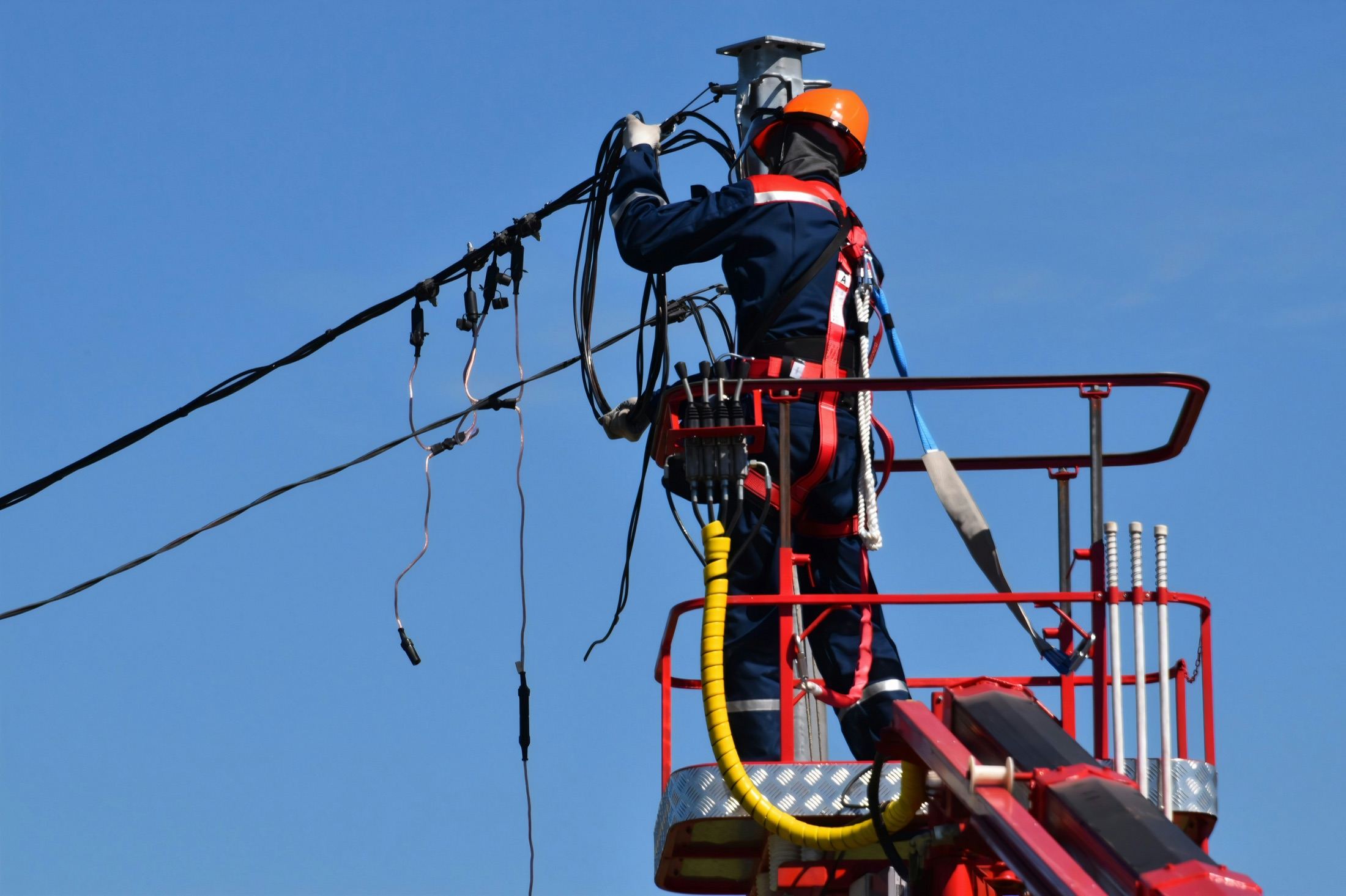 Technicien sur nacelle intervenant sur une ligne électrique aérienne